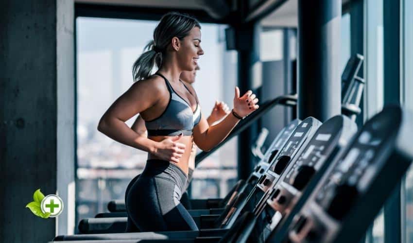 Two woman running on a treadmill in a post about does cardio kill gains