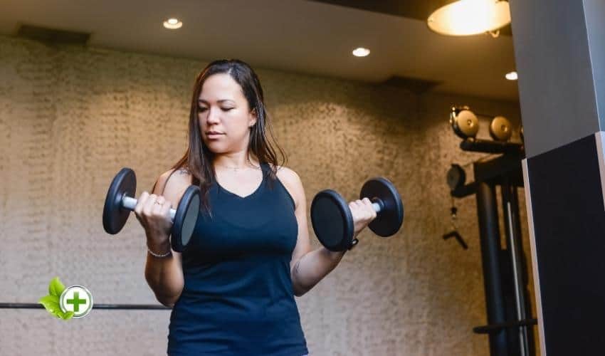 A woman lifting weights in a post about does cardio kill gains
